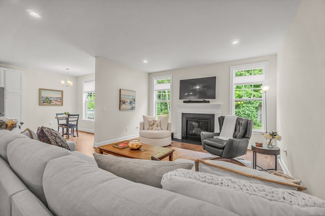 living room with a chandelier, light hardwood / wood-style floors, and a wealth of natural light