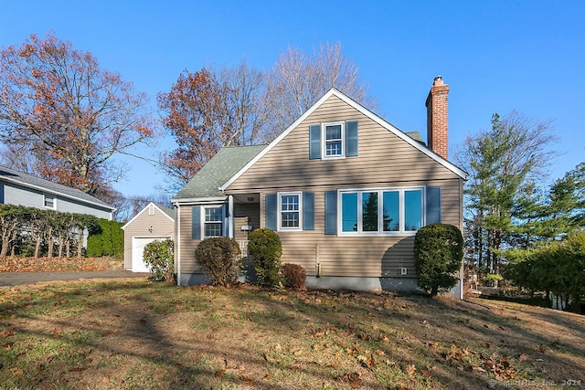 view of front of home featuring a garage, an outdoor structure, and a front yard