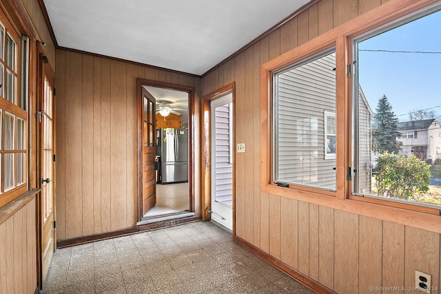 doorway to outside with wood walls