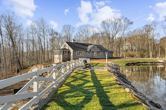 view of home's exterior featuring a water view and a lawn