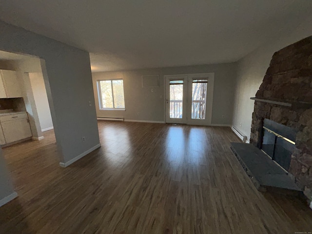 unfurnished living room featuring a stone fireplace, a baseboard radiator, and dark hardwood / wood-style floors