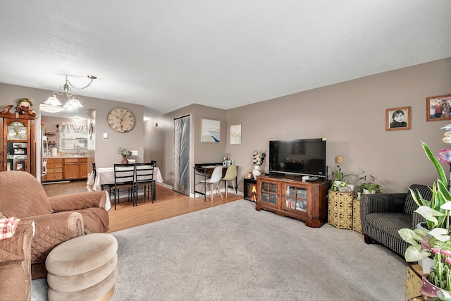 living room featuring sink, light carpet, and a chandelier