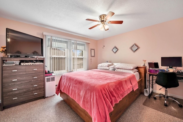 bedroom with ceiling fan, carpet floors, and a textured ceiling