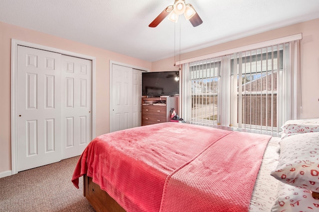 bedroom featuring ceiling fan, multiple closets, and carpet