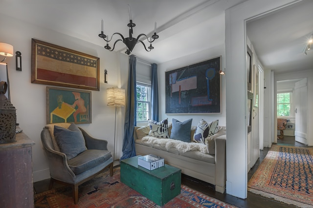 living room featuring a chandelier and dark wood-type flooring