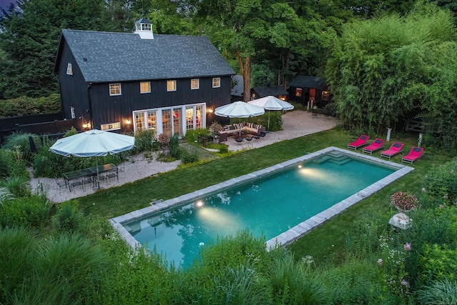 view of pool with a patio area and a lawn