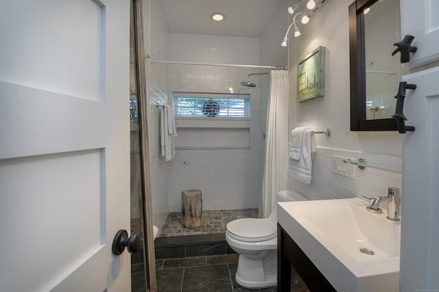 bathroom featuring tile patterned floors, a shower with curtain, vanity, tile walls, and toilet