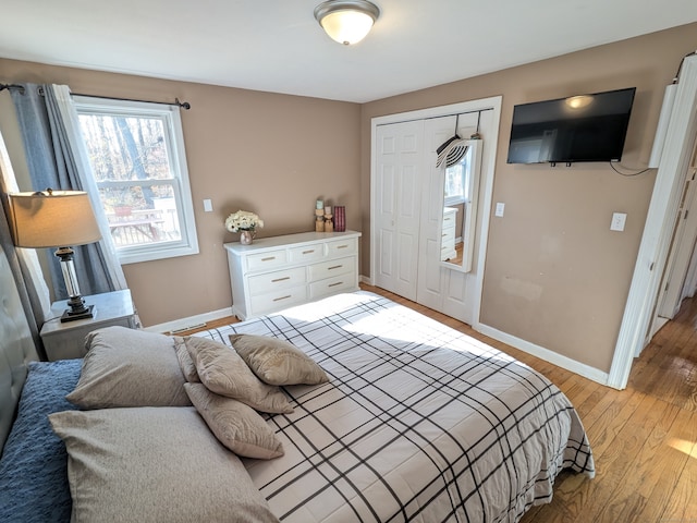 bedroom with light hardwood / wood-style flooring and a closet