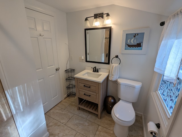 bathroom featuring vanity, lofted ceiling, and toilet