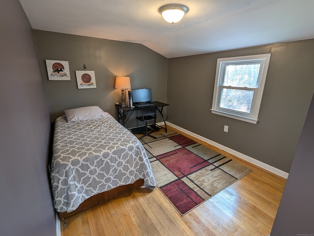 bedroom with hardwood / wood-style floors and vaulted ceiling