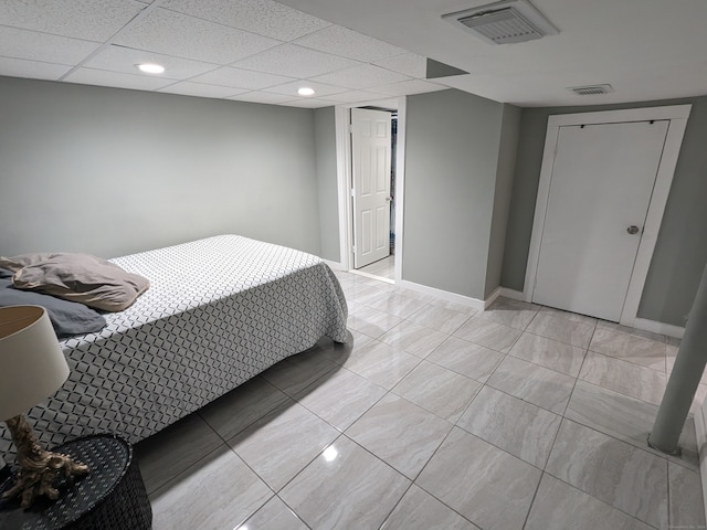 tiled bedroom featuring a paneled ceiling