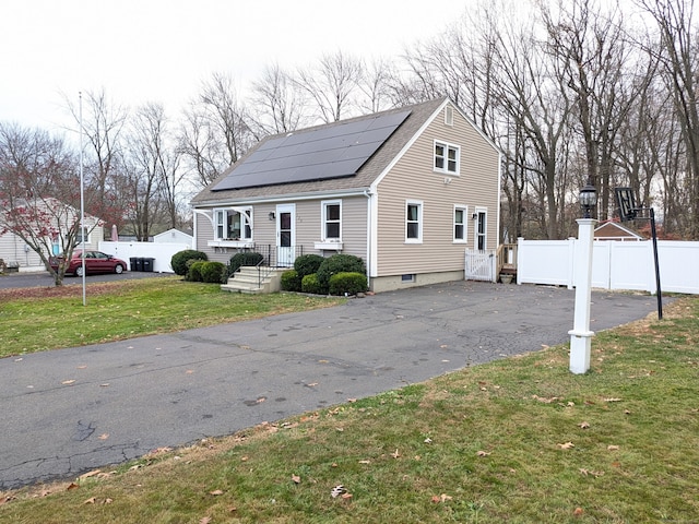 exterior space featuring solar panels and a front lawn