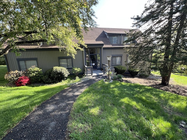 view of front of home featuring a front lawn and roof with shingles