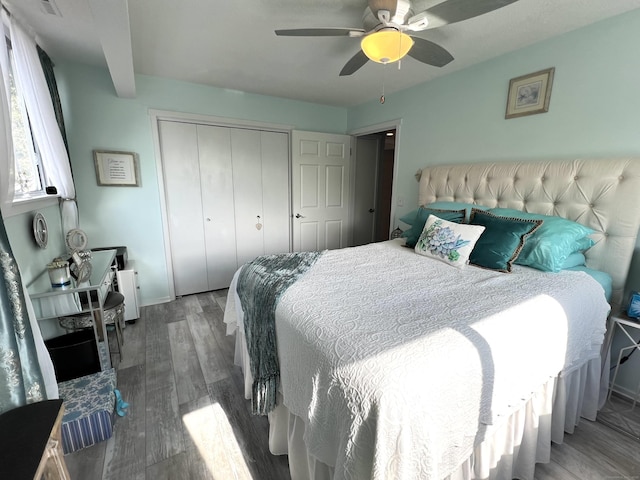 bedroom with a closet, wood finished floors, ceiling fan, and baseboards