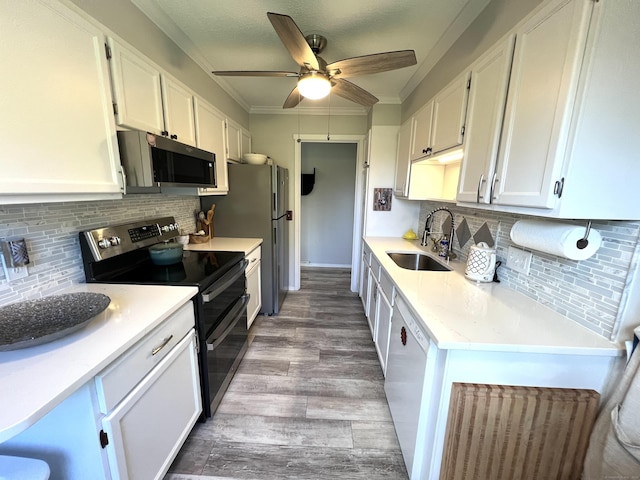 kitchen with a sink, appliances with stainless steel finishes, white cabinets, wood finished floors, and decorative backsplash