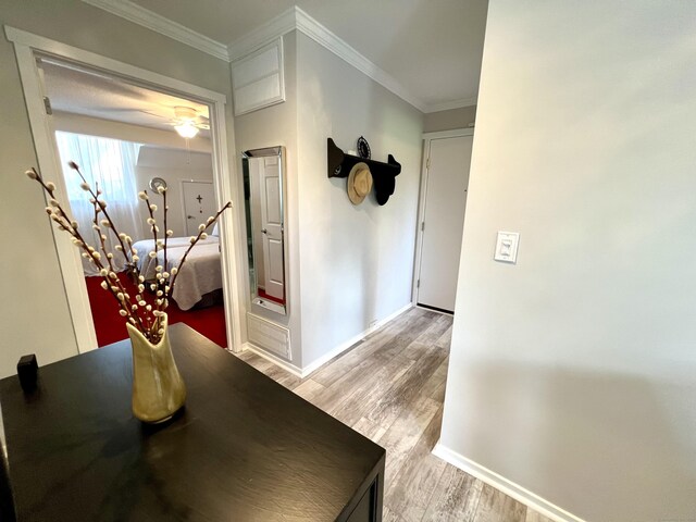 hall with wood finished floors, baseboards, ornamental molding, and a chandelier