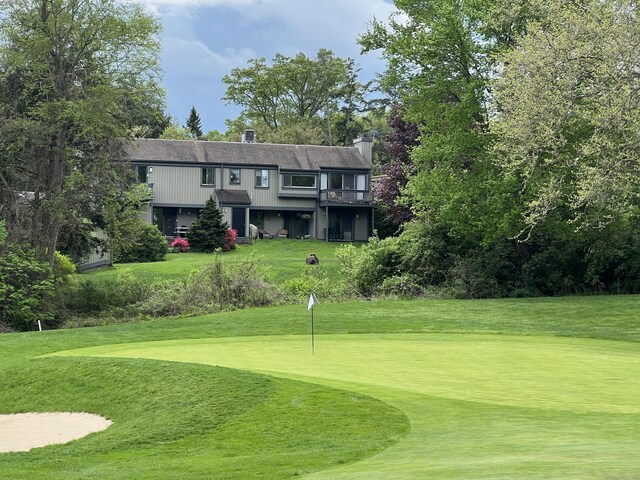 view of community with a lawn and view of golf course