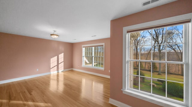 interior space featuring baseboards, light wood-type flooring, and visible vents