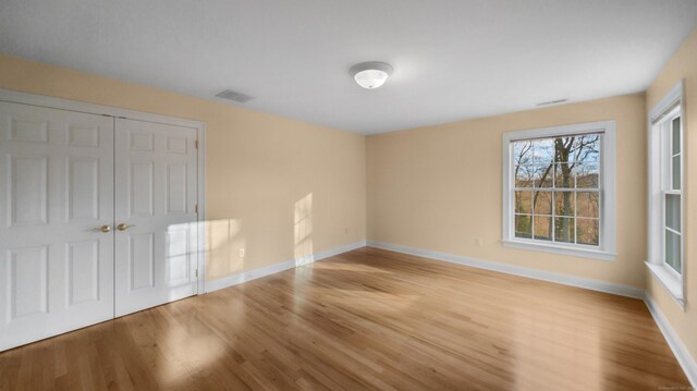 interior space featuring visible vents, light wood-type flooring, and baseboards