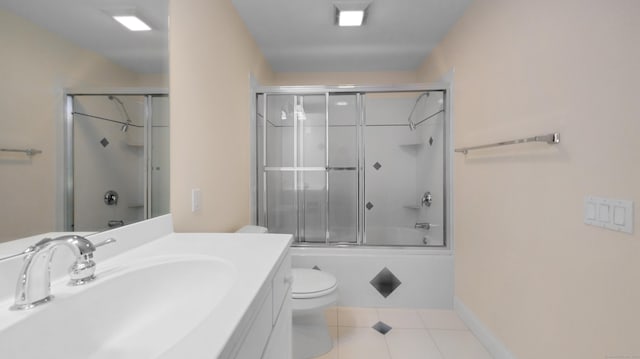 full bathroom with tile patterned flooring, vanity, enclosed tub / shower combo, and toilet