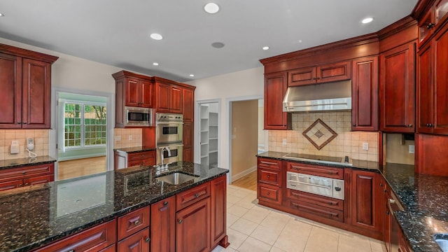 kitchen featuring light tile patterned flooring, stainless steel appliances, dark stone countertops, and sink