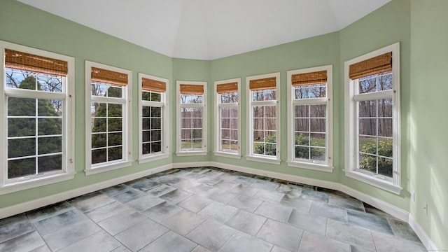 unfurnished sunroom featuring plenty of natural light and vaulted ceiling