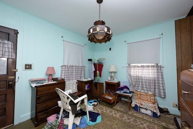 misc room with dark colored carpet, wood walls, and ornamental molding