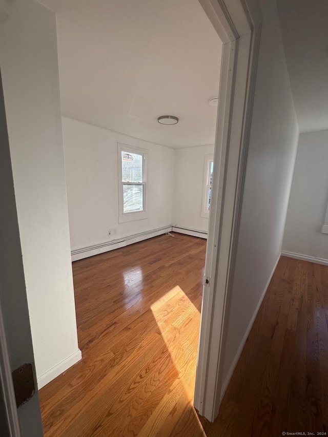 interior space with hardwood / wood-style floors and a baseboard heating unit