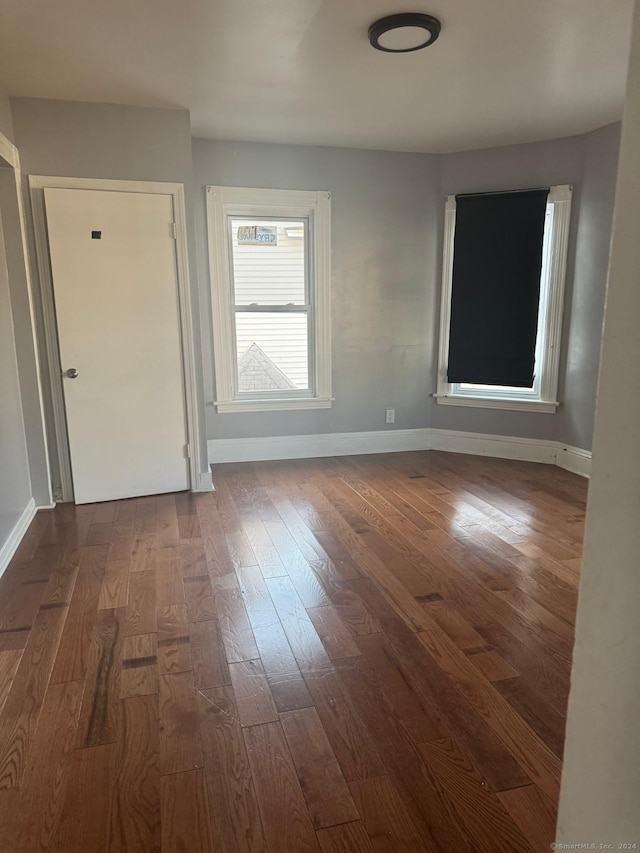 unfurnished room with dark wood-type flooring