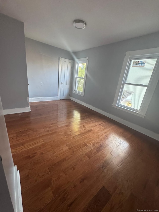 unfurnished room with dark hardwood / wood-style flooring