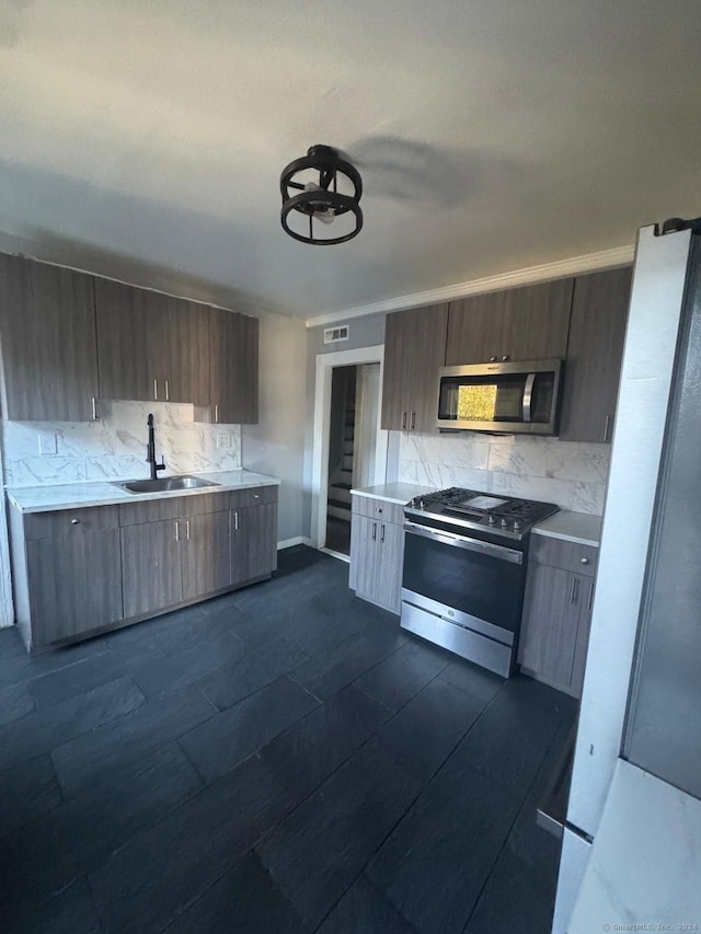 kitchen featuring appliances with stainless steel finishes, backsplash, and sink