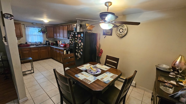 dining room featuring ceiling fan, light tile patterned floors, and sink