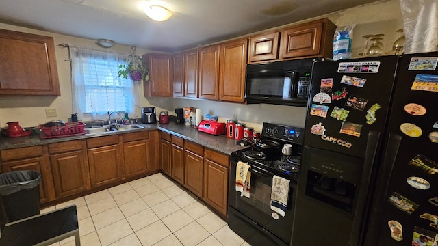 kitchen with light tile patterned floors, sink, and black appliances