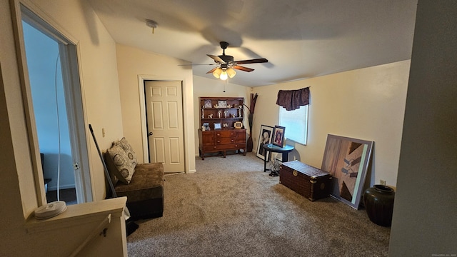 living area featuring carpet, ceiling fan, and lofted ceiling