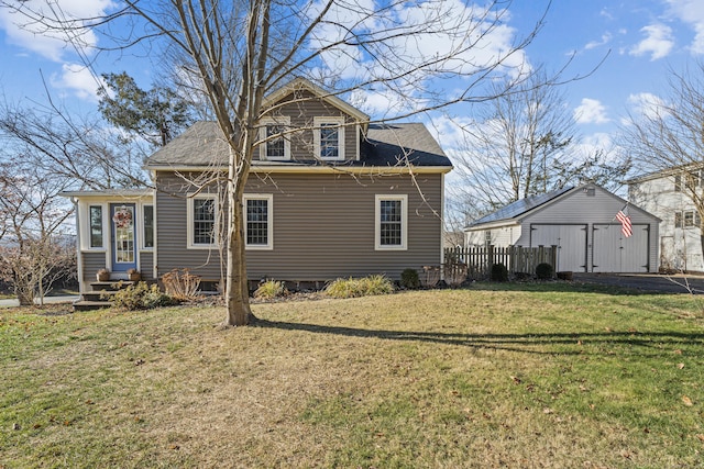 back of property featuring an outbuilding, a garage, and a lawn