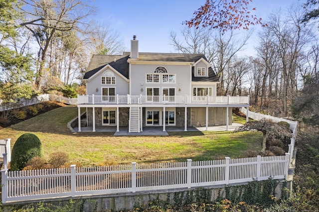 rear view of house featuring a yard, a patio area, and a wooden deck