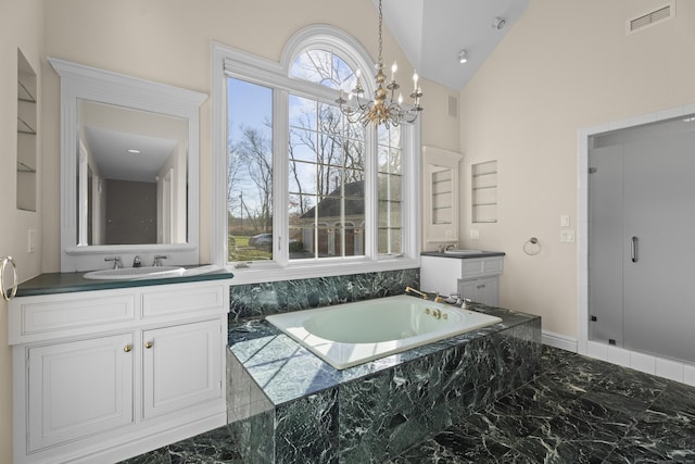 bathroom with a chandelier, vanity, tiled bath, and high vaulted ceiling