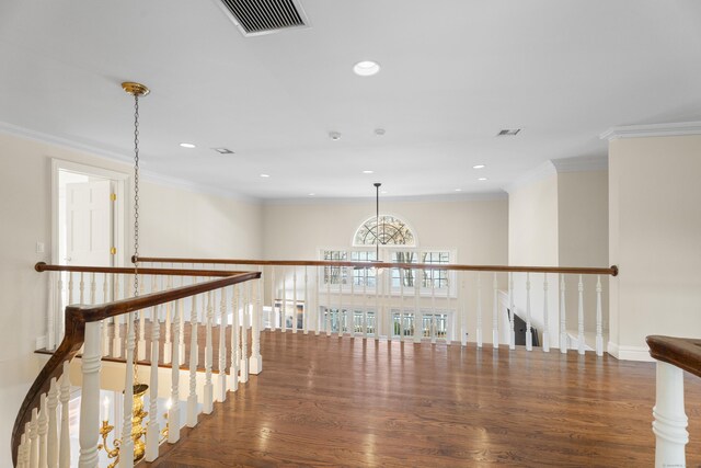 hall with dark hardwood / wood-style floors, an inviting chandelier, and ornamental molding