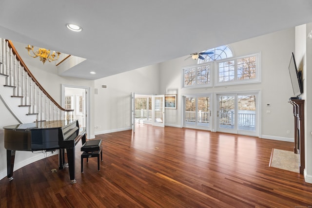 interior space with a wealth of natural light, hardwood / wood-style floors, and ceiling fan with notable chandelier