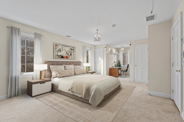 carpeted bedroom with a notable chandelier