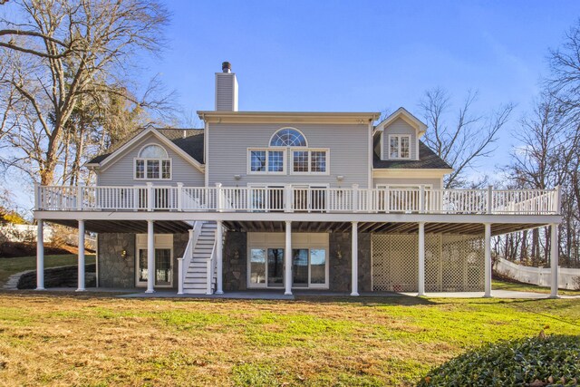 rear view of house featuring a deck and a yard