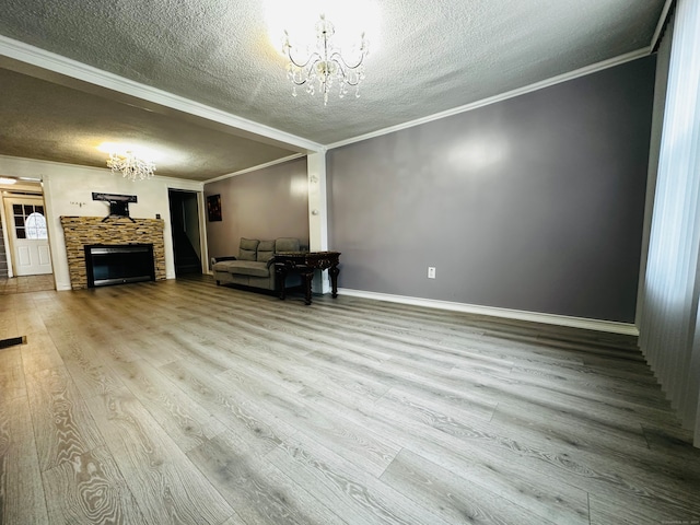 unfurnished living room featuring a fireplace, wood-type flooring, a textured ceiling, and crown molding