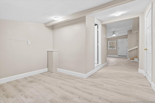 hallway with light wood-type flooring and vaulted ceiling