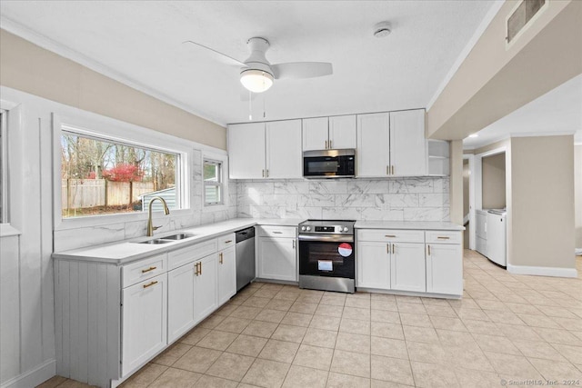 kitchen featuring appliances with stainless steel finishes, washing machine and clothes dryer, white cabinetry, sink, and backsplash