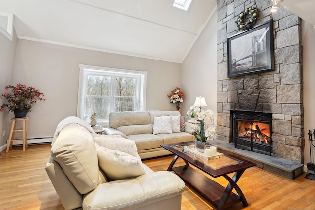 living room featuring a stone fireplace, a skylight, high vaulted ceiling, light hardwood / wood-style flooring, and baseboard heating