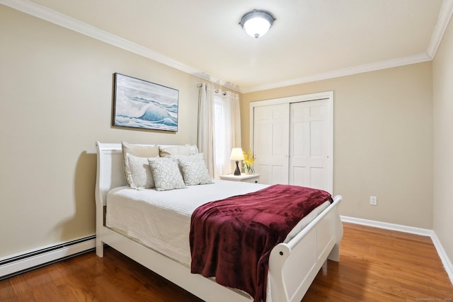 bedroom featuring dark hardwood / wood-style flooring, crown molding, a closet, and baseboard heating