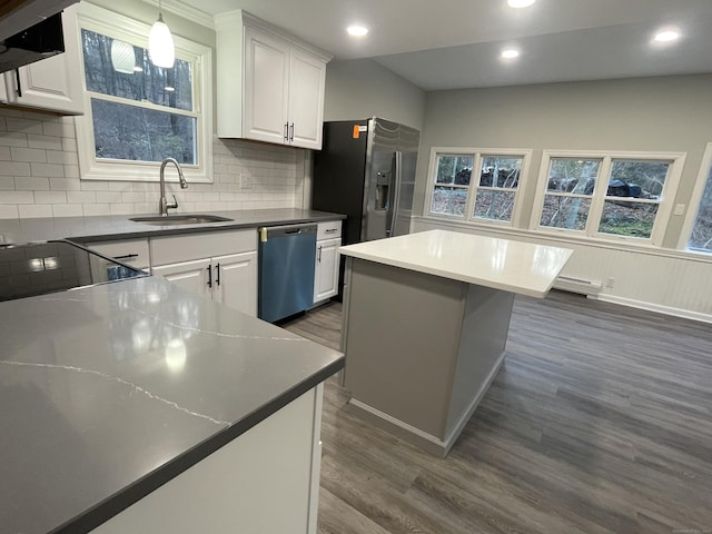 kitchen featuring stainless steel appliances, sink, white cabinetry, and a center island