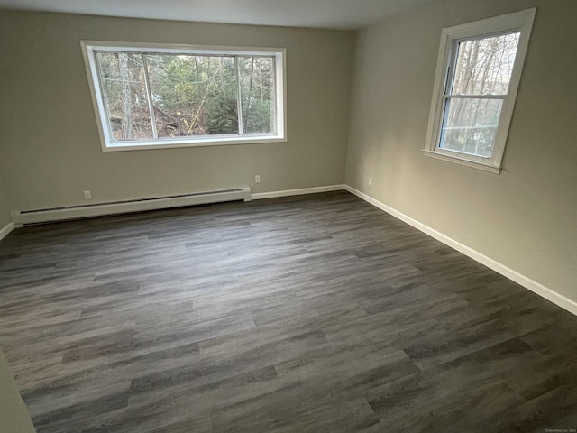 spare room featuring a baseboard radiator and dark hardwood / wood-style flooring