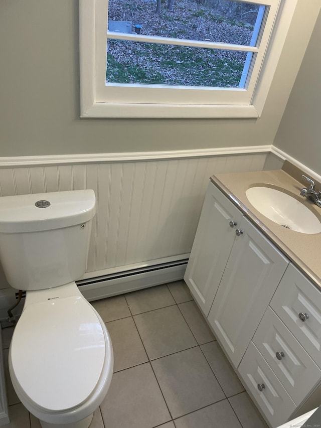 bathroom with baseboard heating, tile patterned floors, toilet, and vanity