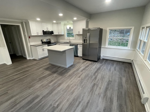 kitchen featuring stainless steel appliances, white cabinetry, a kitchen island, and sink